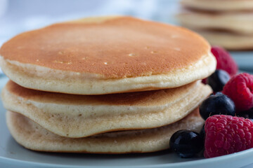 Fluffy pancake stack with raspberries and blueberries