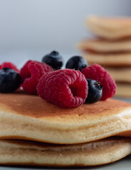 Fluffy pancake stack with raspberries and  blueberries