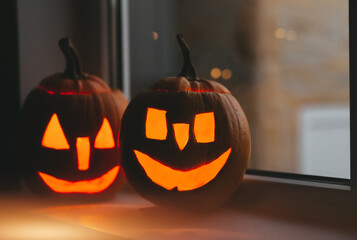 Happy Halloween day. Halloween pumpkins at windows with bokeh. 