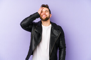 Young man isolated on purple background laughing happy, carefree, natural emotion.