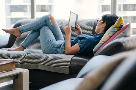 Young Woman Holding Ereader And Reading Ebook