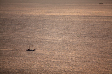 Obraz premium silhouette sailing boat view on the shimmering sea