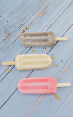 Strawberry; Chocolate, Vanilla Popsicle in Blue Background