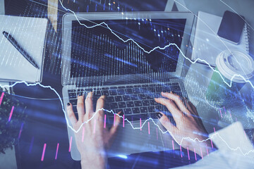 Double exposure of woman hands typing on computer and forex chart hologram drawing. Stock market invest concept.