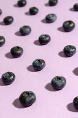 pattern of blueberries on violet background. Top view. Flat lay