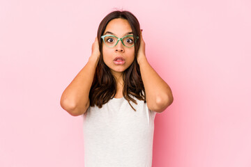 Young mixed race hispanic woman isolated covering ears with hands trying not to hear too loud sound.