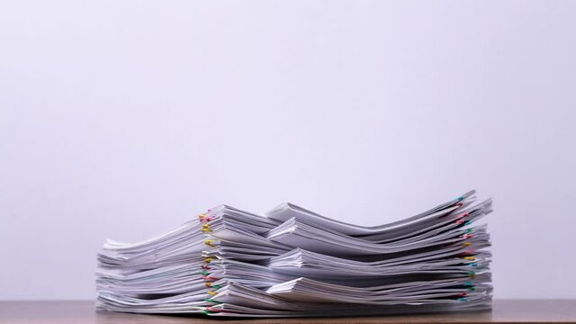 4K Stop of motion close-up stack overload document report paper with paperclip place increase on white background, business and education concept footage paperless used. 