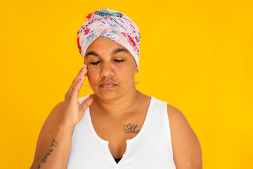 stressed woman with eyes closed and hand to face on yellow background