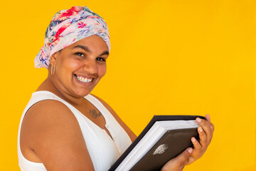 smiling woman with book on coloured yellow background