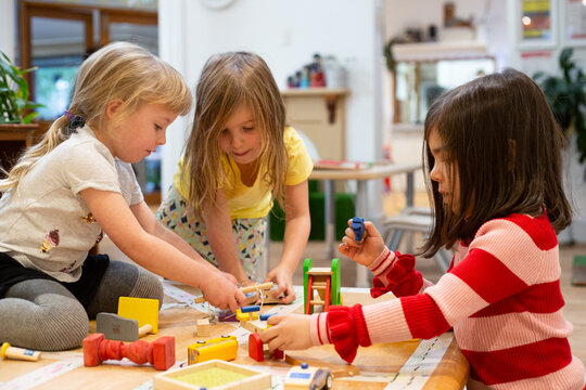 Three little girls playing at pre-school