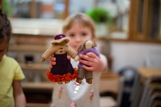 Child showing two felt international dolls
