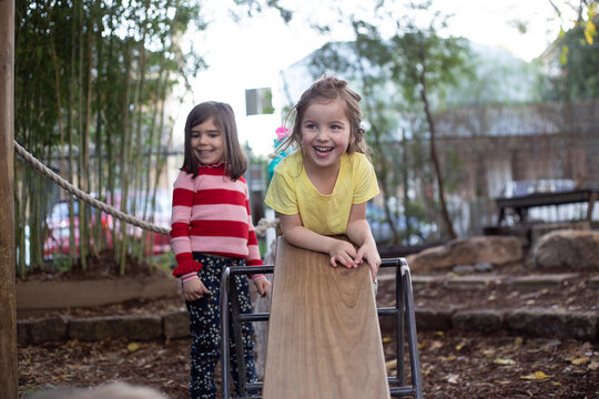 Young girl on wooden see-saw