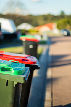 Rubbish and green bins out on quiet town street awaiting collection