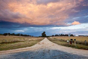A country road leads off into the distance an under storm clouds
