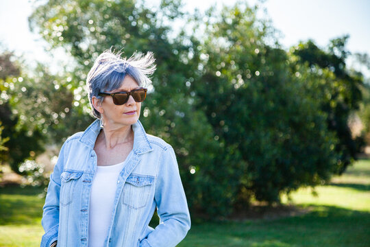 portrait of a senior woman in the garden wearing sunglasses