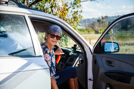 Happy mature aged woman getting into her car