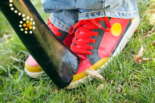 A didgeridoo rests on coloured sneakers