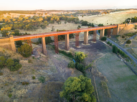 Looking down on a long railway bridge over dry valley