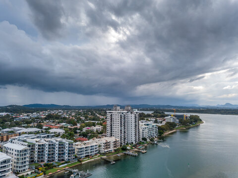 Aerial view of hi rise buildings on a waterfront under dark storm clouds