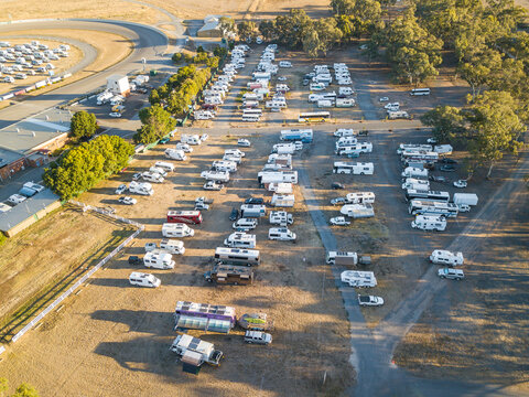Aerial view of lots of motorhomes parked on rows on a reserve