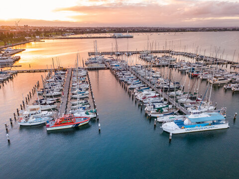 Looking down on rows of boats and yachts at a marina at sunset