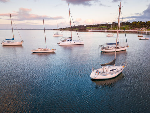 Looking down on yachts anchored in a bay on a calm evening