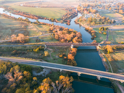 Aerial view of bridges spanning a river lined with Autumn trees