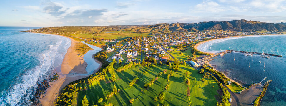 Aerial view a golf course and coastal town with ocean on both sides