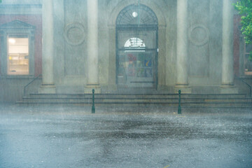 Heavy rain battering the facade of an historic buildings with prominent columns
