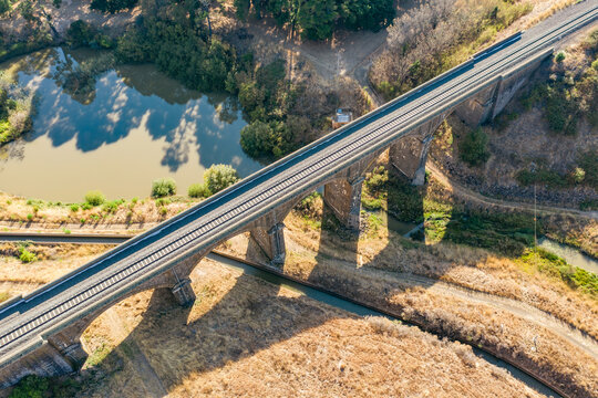 Aerial view of a stone viaduct over a river and water channel