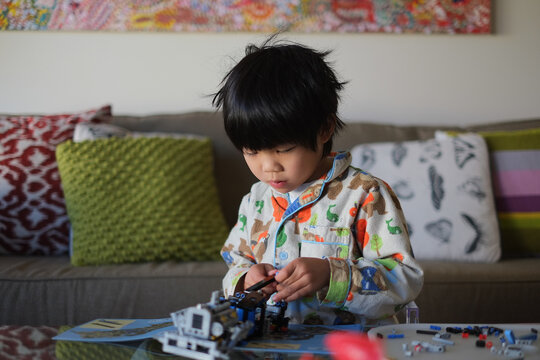 A Kid Building A Lego Piece