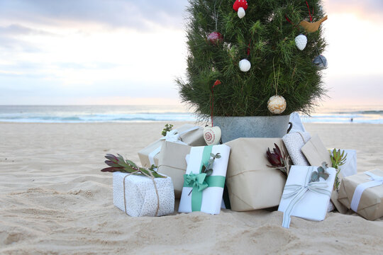 Decorated Christmas tree with presents and beach in background