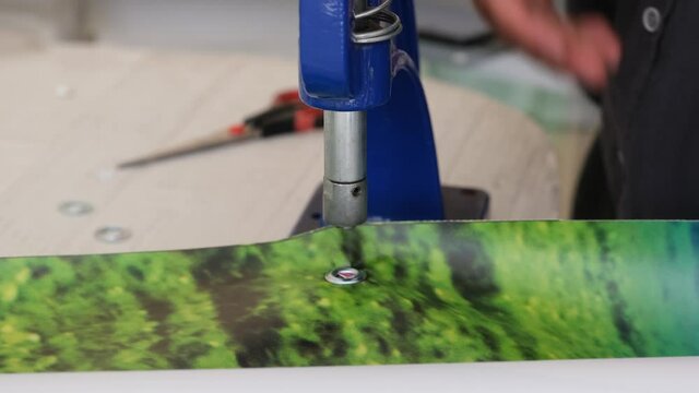 People using eyelet machine. Hole punch machine.