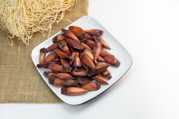 Pinhão, pinion,pine fruit, Brazilian Araucária tree, on the plate on white background