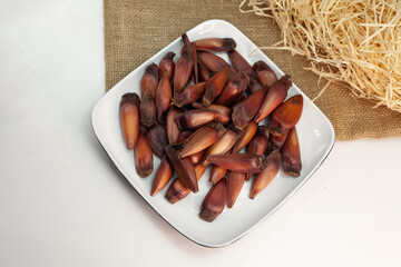Pinhão, pinion,pine fruit, Brazilian Araucária tree, on the plate on white background