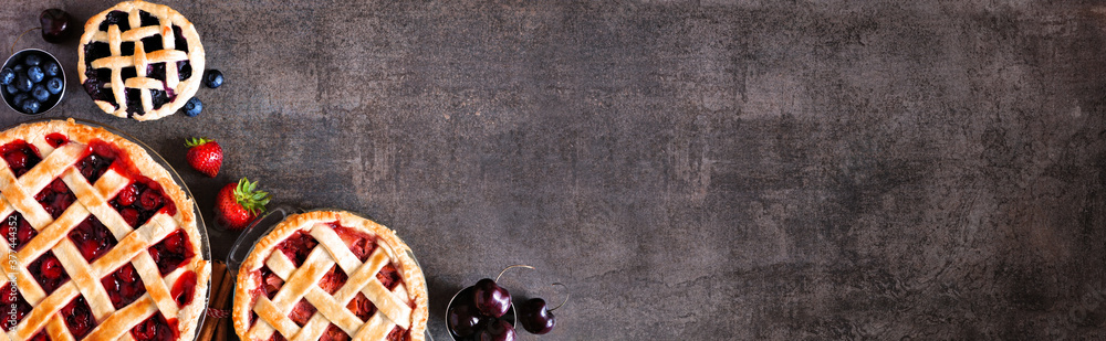 Poster selection of fresh fruit pies. above view corner border over a dark stone background with copy space