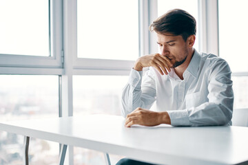 sad man of european appearance at the table indoors 