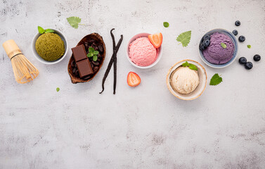 Various of ice cream  flavours in bowl blueberry ,green tea ,coconut ,strawberry and chocolate  setup on white stone background .