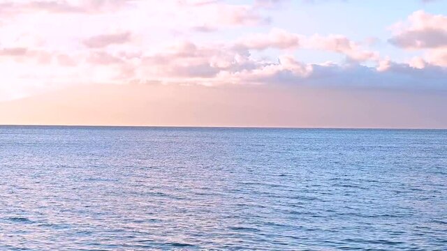 Pastel pink and blue sky and the ocean, horizon
