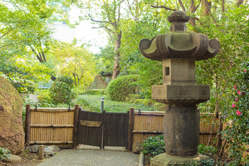 small wooden traditional gate and stone lantern in japanese  garden in tokyo, japan