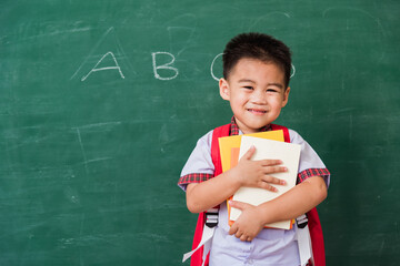 Back to School. Happy Asian funny cute little child boy from kindergarten in student uniform with...
