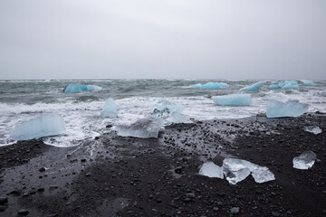 Black sand strewn with iceberg chunks on Diamond Beach, Iceland