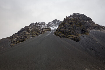 Black volcanic mountain with unique top formations in Iceland