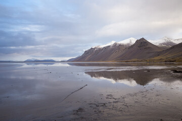 Reflection of snowcapped mountain at low tide