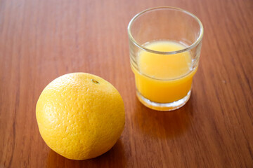 glass of orange juice and orange