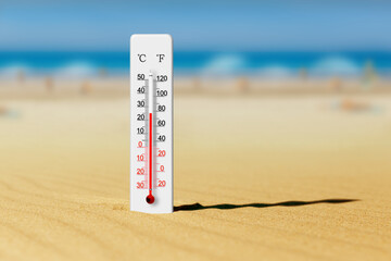 Sea coast at hot summer day. Wooden thermometer in the sand. Ambient temperature plus 25 degrees celsius