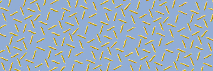 Fusilli pasta random flat lay on blue background without shadow. can be used as raw pasta background, poster, banner not pattern.