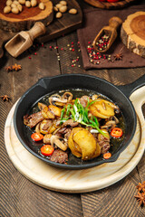 Roasted potatoes and beef meat in cast iron pan