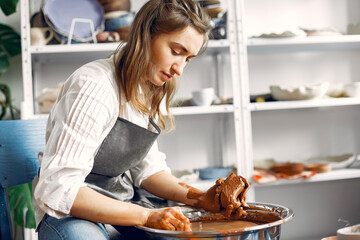 Girl make a vase. Pottery theme. On a pottery's machine.