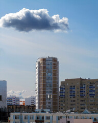 Fototapeta na wymiar Cloud over a multi-storey building - it will rain soon